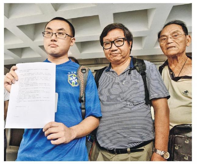 任職侍應的愛港之聲成員陳嘉偉(左),因不滿立法會秘書長裁定11名民主派立法會議員宣誓有效,昨於愛港之聲召集人高達斌(中)陪同下入稟高院申請司法覆核,要求法庭推翻有關決定。(鍾林枝攝) 任職侍應的愛港之聲成員陳嘉偉(左),因不滿立法會秘書長裁定11名民主派立法會議員宣誓有效,昨於愛港之聲召集人高達斌(中)陪同下入稟高院申請司法覆核,要求法庭推翻有關決定。(鍾林枝攝)
