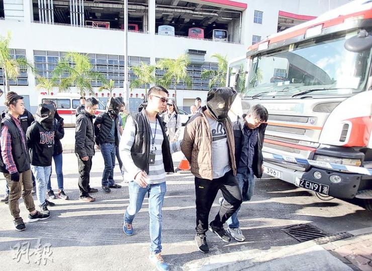 O記搗破陸路偷運人蛇集團,於長沙灣興華街西即場拘捕5人,包括圖中貨櫃車司機(啡外套)及偷運的兩名非法入境者。(伍浦鋒攝) O記搗破陸路偷運人蛇集團,於長沙灣興華街西即場拘捕5人,包括圖中貨櫃車司機(啡外套)及偷運的兩名非法入境者。(伍浦鋒攝)