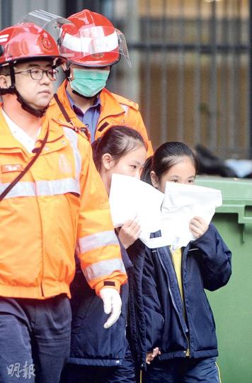 保良局何壽南小學昨有12名學生集體不適,出現嘔吐頭暈徵狀,需要送院治理;圖為其中兩名女學生手持白色嘔吐袋,隨救護員上救護車送院。(賴俊傑攝) 保良局何壽南小學昨有12名學生集體不適,出現嘔吐頭暈徵狀,需要送院治理;圖為其中兩名女學生手持白色嘔吐袋,隨救護員上救護車送院。(賴俊傑攝)