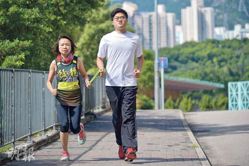 視障人士James(右)捉着繩,在領跑員Ling(左)帶領下跑步。他們將出戰沖繩馬拉松十公里比賽。今次是Ling首次擔任領跑員,期望多練習磨合,習慣彼此步速後,成為James的「眼睛」。(蘇智鑫攝) 視障人士James(右)捉着繩,在領跑員Ling(左)帶領下跑步。他們將出戰沖繩馬拉松十公里比賽。今次是Ling首次擔任領跑員,期望多練習磨合,習慣彼此步速後,成為James的「眼睛」。(蘇智鑫攝)