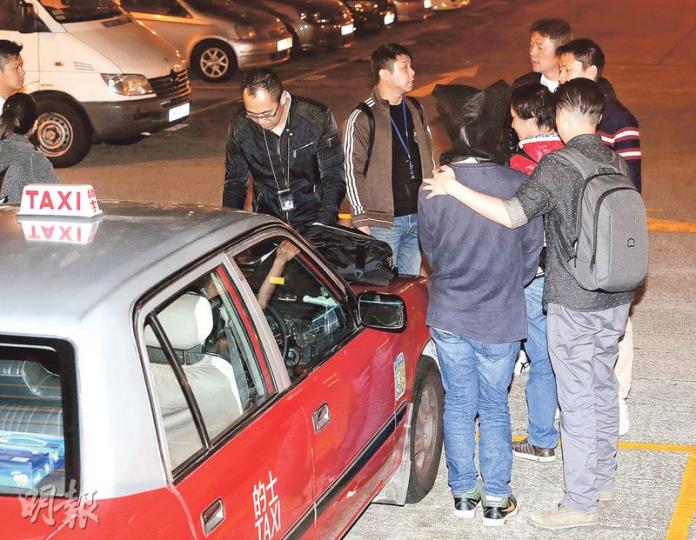 48歲鄒姓的士司機(前右二黑布蒙頭者)涉嫌將女乘客在車廂內餵哺母乳片段上網, 警方昨日將其拘捕,並將他押到早前已扣押在深水埗警署內的涉案的士旁調查。(伍浦鋒攝) 48歲鄒姓的士司機(前右二黑布蒙頭者)涉嫌將女乘客在車廂內餵哺母乳片段上網, 警方昨日將其拘捕,並將他押到早前已扣押在深水埗警署內的涉案的士旁調查。(伍浦鋒攝)