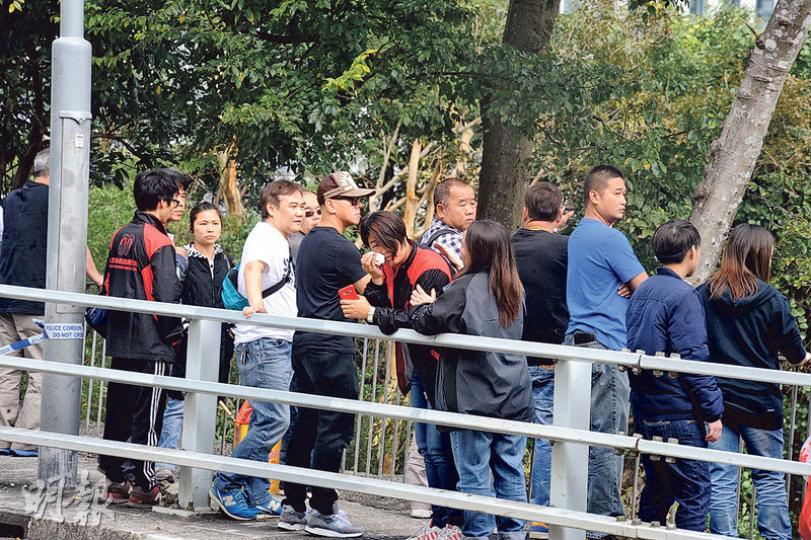 死者50多名親友下午在事發現場拜祭，死者妻子（手執紙巾、紅黑風褸）傷心不已，不時掩面拭淚。（衛永康攝）
