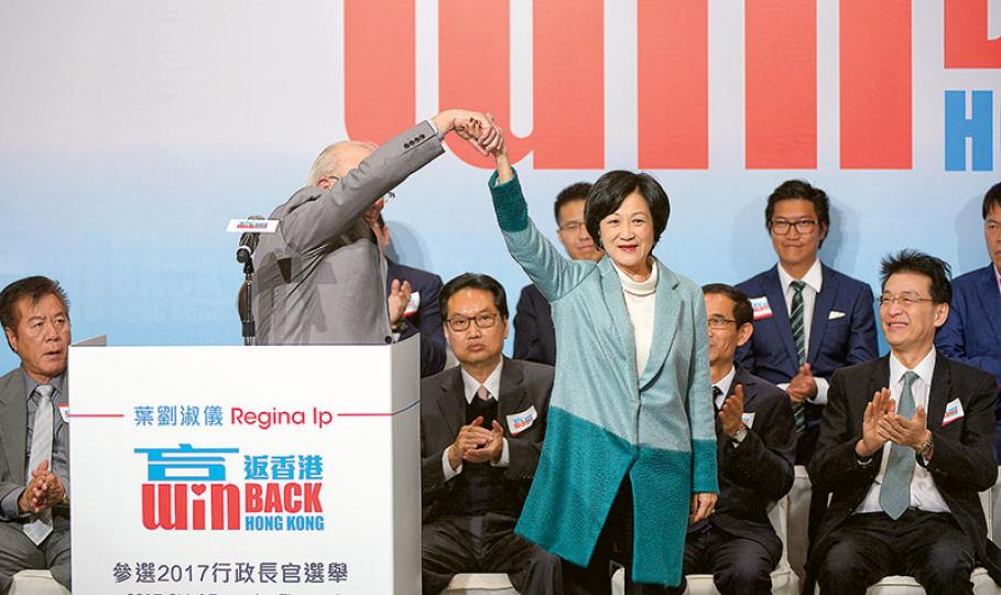 89歲的前布政司鍾逸傑(前左)由上屆支持梁振英,轉為今屆支持新民黨葉劉淑儀(前右)參選特首,直言「是時候改變」,又大讚沒有人比葉太更了解香港問題。圖為鍾逸傑在台上手牽手為葉太打氣,布景板則寫有葉太的競選口號「贏返香港」。(鍾林枝攝)葉劉淑儀昨一口氣在台上宣讀了近一小時的政綱內容,台上嘉賓有些忍不住打呵欠,多人閉目養神,有人垂頭疑似打瞌睡。(郭慶輝攝) 89歲的前布政司鍾逸傑(前左)由上屆支持梁振英,轉為今屆支持新民黨葉劉淑儀(前右)參選特首,直言「是時候改變」,又大讚沒有人比葉太更了解香港問題。圖為鍾逸傑在台上手牽手為葉太打氣,布景板則寫有葉太的競選口號「贏返香港」。(鍾林枝攝)葉劉淑儀昨一口氣在台上宣讀了近一小時的政綱內容,台上嘉賓有些忍不住打呵欠,多人閉目養神,有人垂頭疑似打瞌睡。(郭慶輝攝)