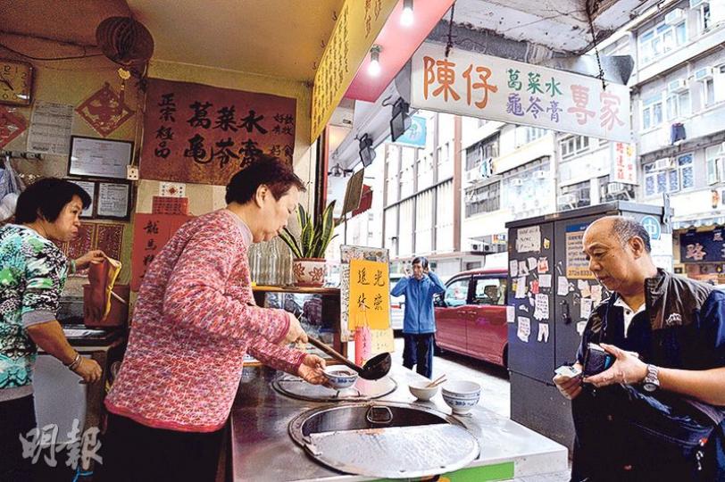 早上開店至中午,賴太(紅衣者)忙得不可開交,前來光顧的客人一個接一個。(馮凱鍵攝)賴先生每天要花上逾10小時煲葛菜水,才能炮製此烏黑透亮的涼茶;賴太用椰殼製作勺子,除了方便一勺可剛好盛載一碗,亦可解熱,細節上盡見心思。(馮凱鍵攝) 早上開店至中午,賴太(紅衣者)忙得不可開交,前來光顧的客人一個接一個。(馮凱鍵攝)賴先生每天要花上逾10小時煲葛菜水,才能炮製此烏黑透亮的涼茶;賴太用椰殼製作勺子,除了方便一勺可剛好盛載一碗,亦可解熱,細節上盡見心思。(馮凱鍵攝)