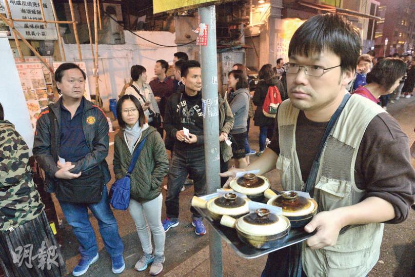 昨夜氣溫顯著下降,廟街賣煲仔飯的食店外大排長龍,有食客認為寒風能為煲仔飯增添風味。(楊栢賢攝) 昨夜氣溫顯著下降,廟街賣煲仔飯的食店外大排長龍,有食客認為寒風能為煲仔飯增添風味。(楊栢賢攝)