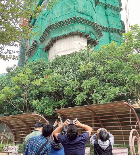 警方重案組探員昨晨到「飛竹」擊斃途人的荃灣柏傲灣地盤附近調查,其間有探員以望遠鏡仰視高處的棚架。(鄧柳媚攝) 警方重案組探員昨晨到「飛竹」擊斃途人的荃灣柏傲灣地盤附近調查,其間有探員以望遠鏡仰視高處的棚架。(鄧柳媚攝)