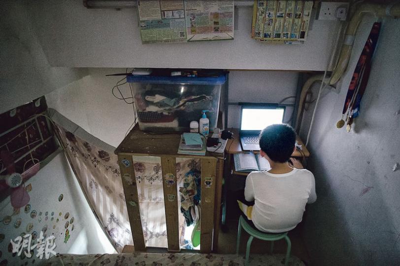 過往因居住的劏房沒有枱椅,9歲的小源(化名)要屈曲身體趴在牀上做功課溫習,去年獲小童群益會送贈書桌和電腦後,終可挺直腰板坐着溫習和上網。(馮凱鍵攝) 過往因居住的劏房沒有枱椅,9歲的小源(化名)要屈曲身體趴在牀上做功課溫習,去年獲小童群益會送贈書桌和電腦後,終可挺直腰板坐着溫習和上網。(馮凱鍵攝)