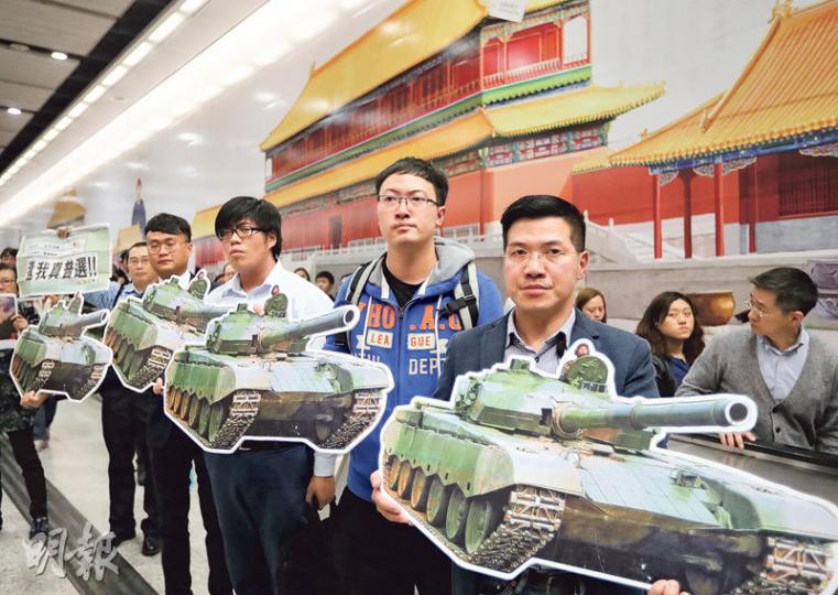 新民主同盟成員昨手持坦克圖片,在香港站故宮壁畫前舉行「民主歌聲獻中環」活動。(郭慶輝攝) 新民主同盟成員昨手持坦克圖片,在香港站故宮壁畫前舉行「民主歌聲獻中環」活動。(郭慶輝攝)