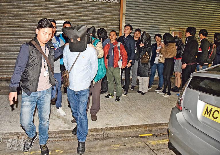 警方旺角區通宵展開「犁庭掃穴」反罪惡行動，共破獲一個毒品飯堂、4個非法賭檔及拘捕53男女；圖為警方在新填地街323號一單位破獲非法賭檔，拘捕主持及多名賭客。（蔡方山攝）