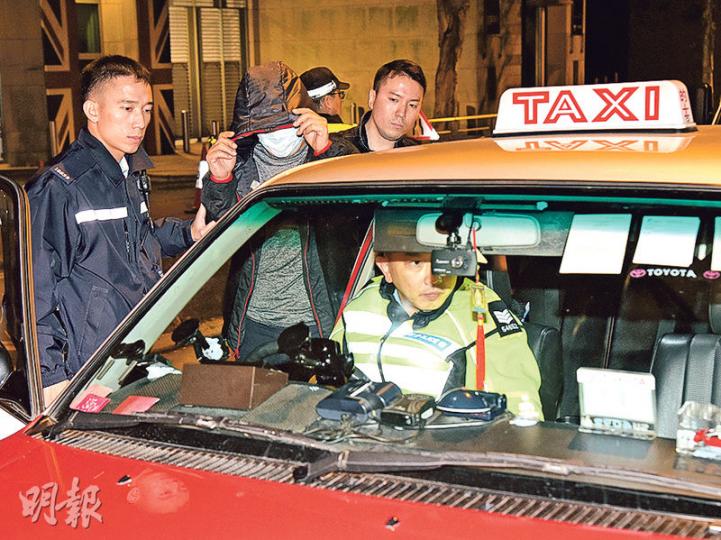 一名曾因濫收車資被罰停牌之的士司機(戴口罩者),昨凌晨在中環蘭桂坊向假扮遊客女警索取「特別晚間收費」100元,「自投羅網」被捕帶署。(蔡方山攝) 一名曾因濫收車資被罰停牌之的士司機(戴口罩者),昨凌晨在中環蘭桂坊向假扮遊客女警索取「特別晚間收費」100元,「自投羅網」被捕帶署。(蔡方山攝)