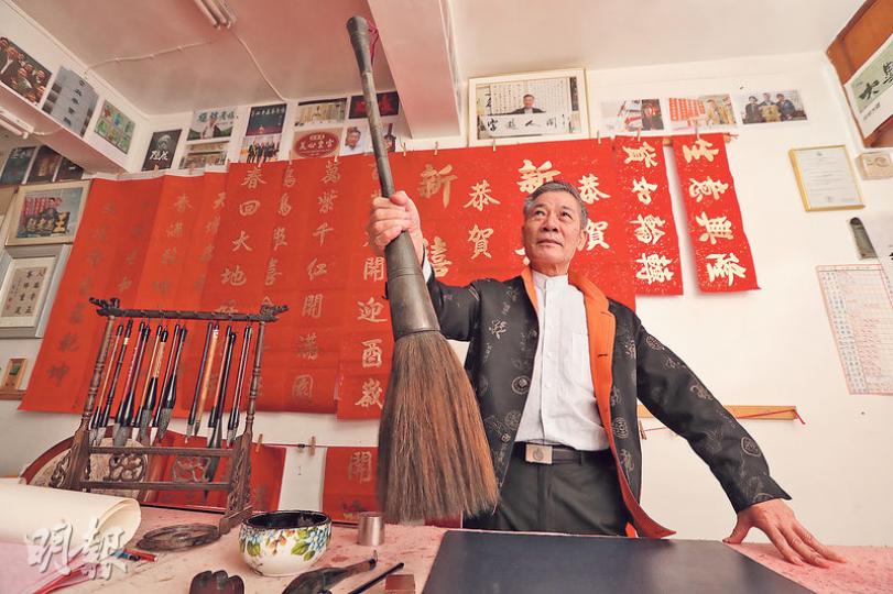 68歲的馮兆華(華戈)自1980年代起,手寫了逾萬個街頭招牌,他年輕時曾手執圖中的巨型毛筆,在20幾層樓高空,為荃灣工廈外牆寫大字。眼見街頭招牌漸漸消失,華戈只能嘆息。(李紹昌攝) 68歲的馮兆華(華戈)自1980年代起,手寫了逾萬個街頭招牌,他年輕時曾手執圖中的巨型毛筆,在20幾層樓高空,為荃灣工廈外牆寫大字。眼見街頭招牌漸漸消失,華戈只能嘆息。(李紹昌攝)
