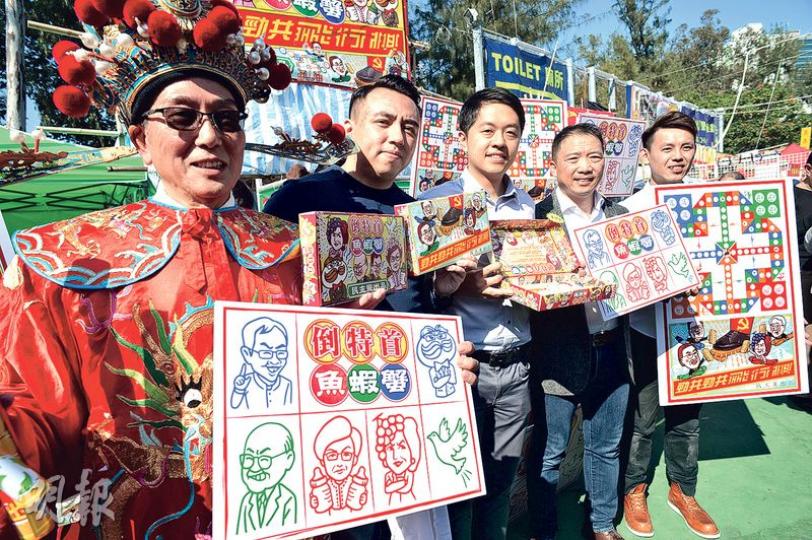 民主黨攤位以兩款諷刺特首選戰嘅遊戲作招徠,包括「倒特首魚蝦蟹」同「勁共」飛行棋,噚日開檔就搵嚟副主席羅健熙(右起)、主席胡志偉同立法會議員許智峯等幫手推銷。(蘇智鑫攝)經民聯年宵攤位搵嚟食衛局長高永文(左二)同副民政局長許曉暉(左四)做嘉賓,該黨雞年主打產品係圖下方嘅小黃鴨產品,玩諧音「香港一定Duck」。(蘇智鑫攝)社民連梁國雄(左)噚日喺年宵攤位捧起「淨含量689克」嘅「長毛牌」午餐肉罐外形咕 民主黨攤位以兩款諷刺特首選戰嘅遊戲作招徠,包括「倒特首魚蝦蟹」同「勁共」飛行棋,噚日開檔就搵嚟副主席羅健熙(右起)、主席胡志偉同立法會議員許智峯等幫手推銷。(蘇智鑫攝)經民聯年宵攤位搵嚟食衛局長高永文(左二)同副民政局長許曉暉(左四)做嘉賓,該黨雞年主打產品係圖下方嘅小黃鴨產品,玩諧音「香港一定Duck」。(蘇智鑫攝)社民連梁國雄(左)噚日喺年宵攤位捧起「淨含量689克」嘅「長毛牌」午餐肉罐外形咕