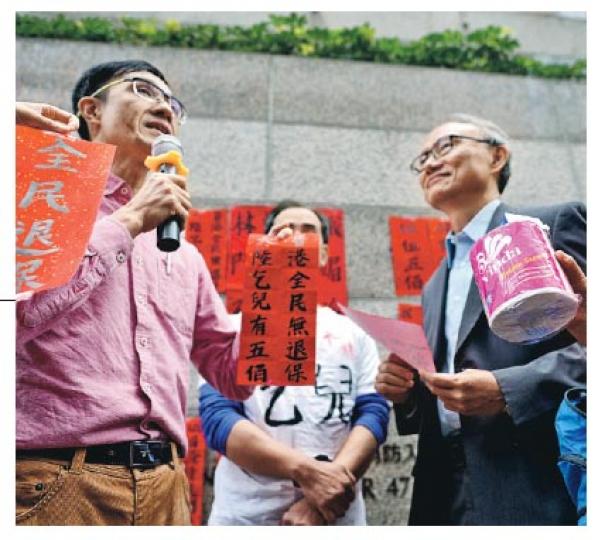 葵青區議員、街工周偉雄(左)昨晨到林鄭月娥現居的會景閣,擬向她致送「大陸乞兒有五佰 香港全民無退保」的揮春,並遞上一卷廁紙,最終競選辦派出公關戴健文接收揮春。(蘇智鑫攝) 葵青區議員、街工周偉雄(左)昨晨到林鄭月娥現居的會景閣,擬向她致送「大陸乞兒有五佰 香港全民無退保」的揮春,並遞上一卷廁紙,最終競選辦派出公關戴健文接收揮春。(蘇智鑫攝)