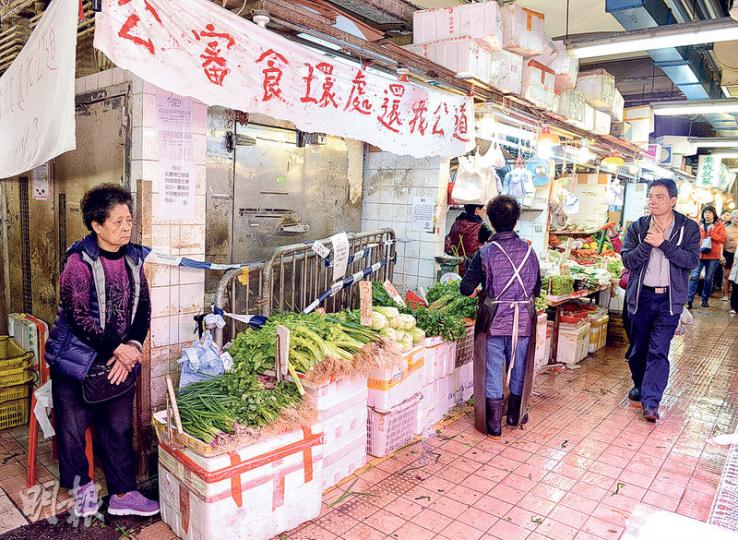 在大成街街市賣菜20年、年過八十的馮婆婆(左)昨早繼續在其被封的檔口前賣菜,其女兒批評食環署「選擇性執法」,並在檔口前掛橫額表達不滿。食環署回應稱,該攤檔一年4次違例被檢控,認為檔主清楚明白違例後果。(劉焌陶攝) 在大成街街市賣菜20年、年過八十的馮婆婆(左)昨早繼續在其被封的檔口前賣菜,其女兒批評食環署「選擇性執法」,並在檔口前掛橫額表達不滿。食環署回應稱,該攤檔一年4次違例被檢控,認為檔主清楚明白違例後果。(劉焌陶攝)