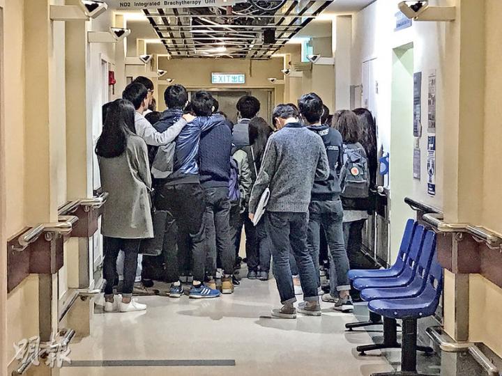 30多名港大師生及傷者親友昨傍晚到醫院探望,其間與張母一同在病房門外低頭祈禱,希望張能渡過危險期。(林智傑攝) 30多名港大師生及傷者親友昨傍晚到醫院探望,其間與張母一同在病房門外低頭祈禱,希望張能渡過危險期。(林智傑攝)