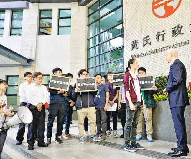 嶺大學生會會長鄭沛倫(前排右二)與其他學生代表昨在校董會開會前到場外請願,校董會主席歐陽伯權(右一)接過請願信,再回應鄭的問題。(蘇智鑫攝) 嶺大學生會會長鄭沛倫(前排右二)與其他學生代表昨在校董會開會前到場外請願,校董會主席歐陽伯權(右一)接過請願信,再回應鄭的問題。(蘇智鑫攝)