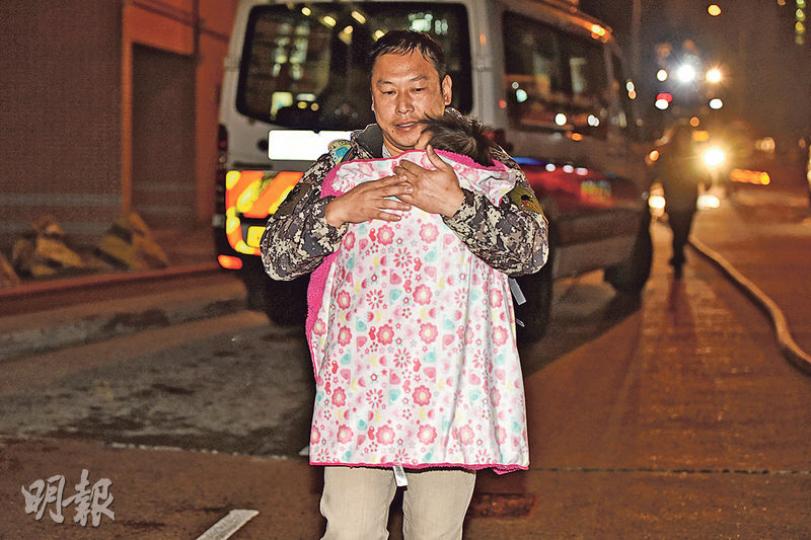 火警期間,有男住客小心翼翼抱同嬰兒走火警,盡顯鐵漢柔情。(蔡方山攝) 火警期間,有男住客小心翼翼抱同嬰兒走火警,盡顯鐵漢柔情。(蔡方山攝)