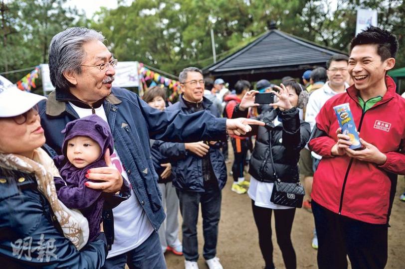 特首參選人曾俊華(左二)昨早現身元朗大欖郊野公園出席善寧會「第25屆登山善行」活動,與參加市民交談,有市民拿着筒裝薯片欲與曾俊華合照(右),曾俊華打趣回應道「行山唔好食薯片」。(蘇智鑫攝) 特首參選人曾俊華(左二)昨早現身元朗大欖郊野公園出席善寧會「第25屆登山善行」活動,與參加市民交談,有市民拿着筒裝薯片欲與曾俊華合照(右),曾俊華打趣回應道「行山唔好食薯片」。(蘇智鑫攝)
