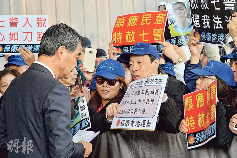 行政會議昨早開會前,有團體到政府總部外請願要求特赦七警,並向特首梁振英(前左)遞信。(楊柏賢攝) 行政會議昨早開會前,有團體到政府總部外請願要求特赦七警,並向特首梁振英(前左)遞信。(楊柏賢攝)