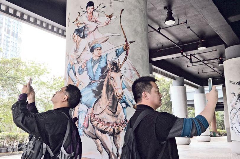 金庸筆下的江湖,常被喻為時局。有七旬金庸迷相信,若世間多一些郭靖,便會少一點紛爭。圖為兩名市民「左右開弓」,在金庸館外一幅印有郭靖(馬上拉弓者)的圖畫兩旁舉起手機拍照。(劉焌陶攝)一眾金庸迷昨趁金庸館開幕後首個周末到場朝聖,入場市民絡繹不絕,博物館因應人數作人流管制,市民要排隊取籌進場,約下午4時有逾40人排隊。(劉焌陶攝)李氏孖仔讀小六,二人自小五開始成為金庸迷,高手過招的場景使他們着迷。哥哥(左)說小說中的武打情節精彩,例如《飛狐外傳》的打鬥場面「拳拳到肉,好緊湊」。弟弟(右)則對《書劍恩仇 金庸筆下的江湖,常被喻為時局。有七旬金庸迷相信,若世間多一些郭靖,便會少一點紛爭。圖為兩名市民「左右開弓」,在金庸館外一幅印有郭靖(馬上拉弓者)的圖畫兩旁舉起手機拍照。(劉焌陶攝)一眾金庸迷昨趁金庸館開幕後首個周末到場朝聖,入場市民絡繹不絕,博物館因應人數作人流管制,市民要排隊取籌進場,約下午4時有逾40人排隊。(劉焌陶攝)李氏孖仔讀小六,二人自小五開始成為金庸迷,高手過招的場景使他們着迷。哥哥(左)說小說中的武打情節精彩,例如《飛狐外傳》的打鬥場面「拳拳到肉,好緊湊」。弟弟(右)則對《書劍恩仇
