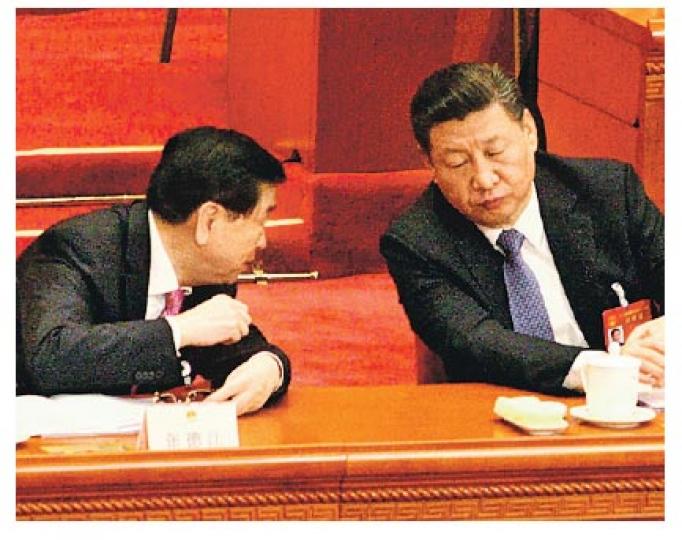 張德江(左)做完報告後回到主席台後,數次與國家主席習近平(右)耳語。(明報記者攝) 張德江(左)做完報告後回到主席台後,數次與國家主席習近平(右)耳語。(明報記者攝)