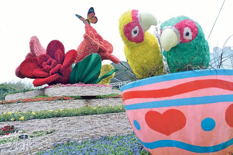 一年一度嘅花展今日起一連10日喺維園舉行,今年花展以「玫瑰」做主題花,場內設有唔少玫瑰花嘅展品,包括其中一個大型展品「瑰麗•情真」,就以四大朵玫瑰花造型雕塑為中心(左);而玫瑰雕塑周圍就設有4個咖啡杯,各有擺設,其中一個就有一對情深依偎嘅愛情鳥(右),象徵愛情。(蘇智鑫攝)由於今年係香港特區成立20周年,今年花展場內特設有一個名為「生日蛋糕」嘅花藝擺設,慶祝呢個重要日子。(蘇智鑫攝) 一年一度嘅花展今日起一連10日喺維園舉行,今年花展以「玫瑰」做主題花,場內設有唔少玫瑰花嘅展品,包括其中一個大型展品「瑰麗•情真」,就以四大朵玫瑰花造型雕塑為中心(左);而玫瑰雕塑周圍就設有4個咖啡杯,各有擺設,其中一個就有一對情深依偎嘅愛情鳥(右),象徵愛情。(蘇智鑫攝)由於今年係香港特區成立20周年,今年花展場內特設有一個名為「生日蛋糕」嘅花藝擺設,慶祝呢個重要日子。(蘇智鑫攝)