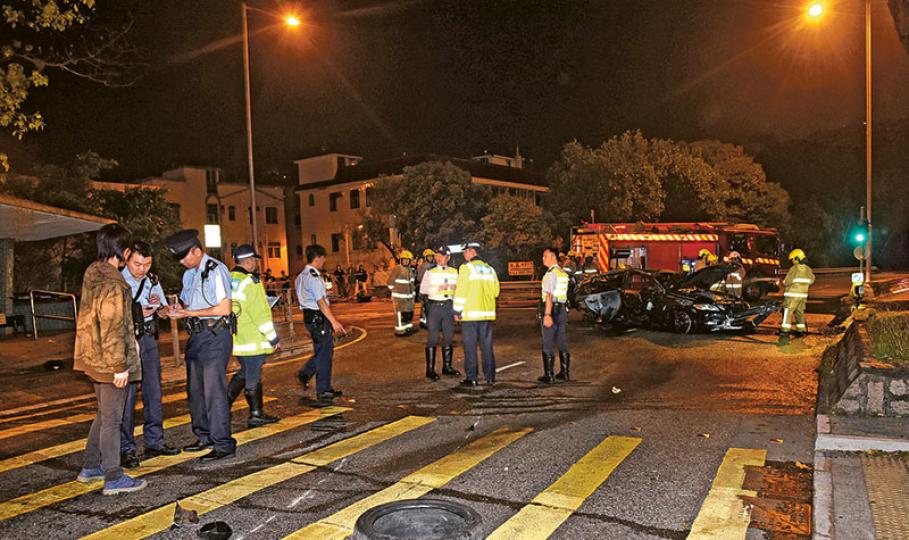 車禍中，肇事凌志失控撞壆掃欄打筋斗，在逾百米外橫亘路中爆炸起火，沿路遺下泵把、死氣喉及輪胎（圖）等組件。（蔡方山攝）肇事凌志連環撞石壆及掃欄後爆炸焚燒（上圖），消防員趕至將火救熄，車廂內發現兩具焦屍（下圖）。（讀者楊先生提供、蔡方山攝）
