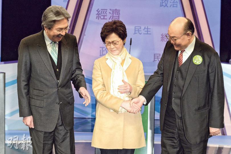 3名候選人第二度同台辯論，昨日在論壇前先讓傳媒拍攝，林鄭月娥（中）被安排站在曾俊華（左）及胡國興（右）中間，記者最初要求3人站近一點，其後再要求他們握手合照，林太伸出雙手，先用右手握着胡國興，後因要轉身用左手反握才能握到曾俊華，在轉身就位時輕皺眉頭。其後現場有觀眾高呼「薯片叔叔加油」，又有人鼓掌，曾俊華因有一隻手鬆動，所以用右手向台下揮手回應。林太則在鬆開後向觀眾揮手。3人中只有胡國興佩戴寫有選舉口號的襟章飾物。（鍾林枝攝）未能取得足夠提名票入閘參選的新民黨主席葉劉淑儀（右）昨晚與一眾黨友觀看選