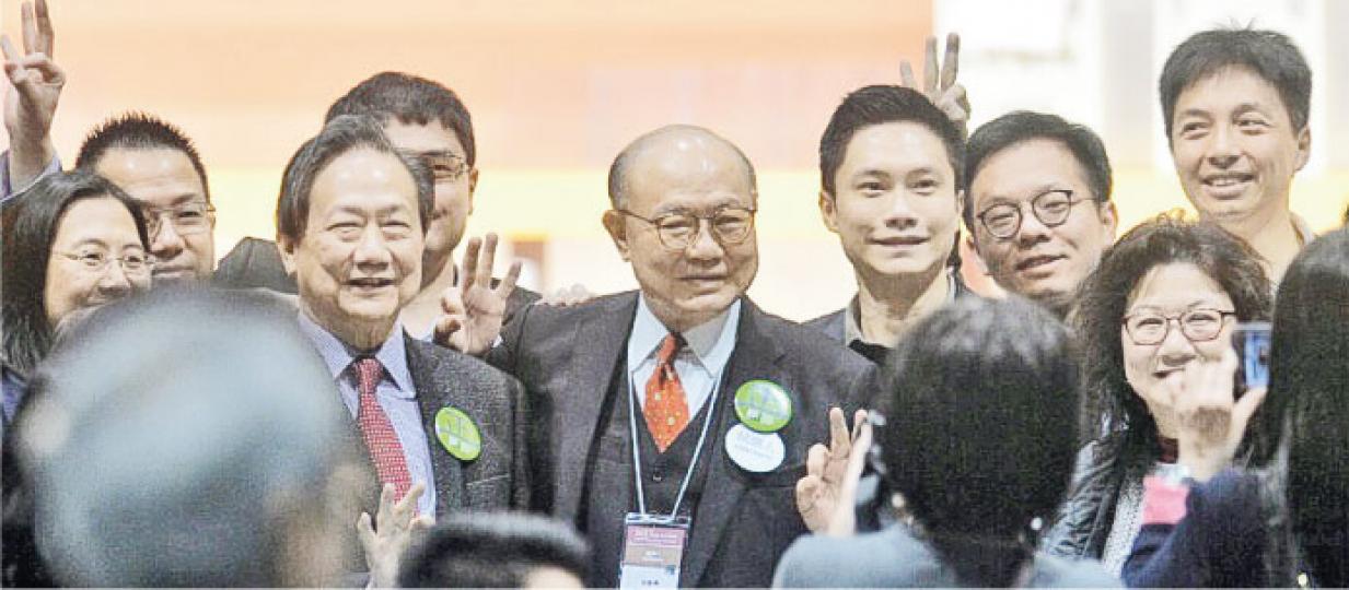 特首候選人胡國興(圖中央面向鏡頭者)得21票,在選舉中落敗,他感謝投票予他的選委,讚揚他們憑良心行事。胡國興在投票結束後與競選團隊及家人於點票中心內合照,面向鏡頭右一為其子胡雅烈,右二為其任幼稚園校長的妹妹胡肖霞。(馮凱鍵攝) 特首候選人胡國興(圖中央面向鏡頭者)得21票,在選舉中落敗,他感謝投票予他的選委,讚揚他們憑良心行事。胡國興在投票結束後與競選團隊及家人於點票中心內合照,面向鏡頭右一為其子胡雅烈,右二為其任幼稚園校長的妹妹胡肖霞。(馮凱鍵攝)