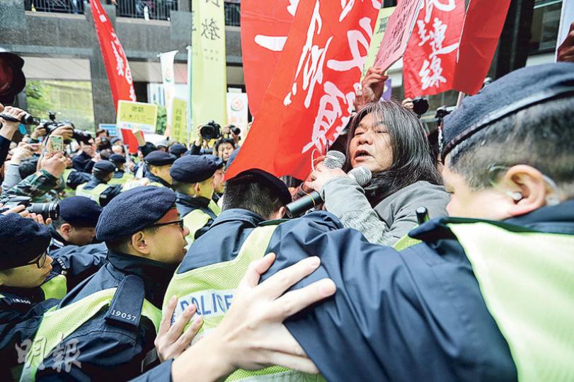 民陣昨早發起「自己政府自己揀」民眾大會,示威者抵達中環廣場後,一度衝出示威區。圖為警方築起人鏈,阻擋立法會議員梁國雄(手持麥克風者)前進,混亂間警方曾舉起黃旗警告示威者。(郭慶輝攝) 民陣昨早發起「自己政府自己揀」民眾大會,示威者抵達中環廣場後,一度衝出示威區。圖為警方築起人鏈,阻擋立法會議員梁國雄(手持麥克風者)前進,混亂間警方曾舉起黃旗警告示威者。(郭慶輝攝)