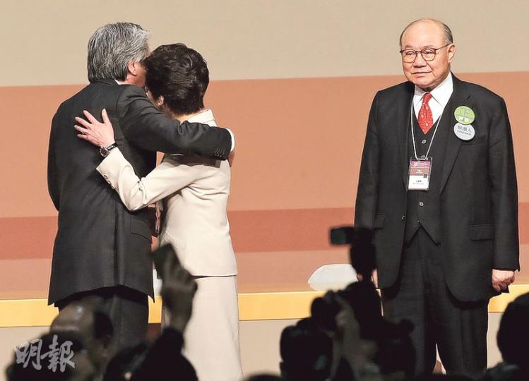 前財政司長曾俊華(左)與前政務司長林鄭月娥(中)選舉期間不時互相攻擊對方任內作風,昨結果公布後兩人不再針鋒相對,勝出的林太多次向台下鞠躬後,便與曾俊華擁抱及互相輕拍對方,之後林太與另一候選人胡國興(右)握手。(李紹昌攝) 前財政司長曾俊華(左)與前政務司長林鄭月娥(中)選舉期間不時互相攻擊對方任內作風,昨結果公布後兩人不再針鋒相對,勝出的林太多次向台下鞠躬後,便與曾俊華擁抱及互相輕拍對方,之後林太與另一候選人胡國興(右)握手。(李紹昌攝)