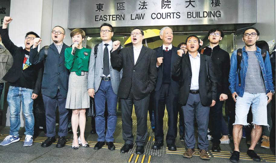 被檢控的9人黃浩銘(左起)、邵家臻、陳淑莊、陳健民、戴耀廷、朱耀明、李永達、張秀賢和鍾耀華昨在入法院前高叫口號「公民抗命,無畏無懼」,他們昨毋須答辯,案件押後至5月25日再訊。(李紹昌攝) 被檢控的9人黃浩銘(左起)、邵家臻、陳淑莊、陳健民、戴耀廷、朱耀明、李永達、張秀賢和鍾耀華昨在入法院前高叫口號「公民抗命,無畏無懼」,他們昨毋須答辯,案件押後至5月25日再訊。(李紹昌攝)