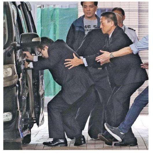被告朱經緯(前排右)離開法院期間,同行者上車時撞向車頂後不慎絆倒,朱即時從後伸手扶起對方。(李紹昌攝) 被告朱經緯(前排右)離開法院期間,同行者上車時撞向車頂後不慎絆倒,朱即時從後伸手扶起對方。(李紹昌攝)