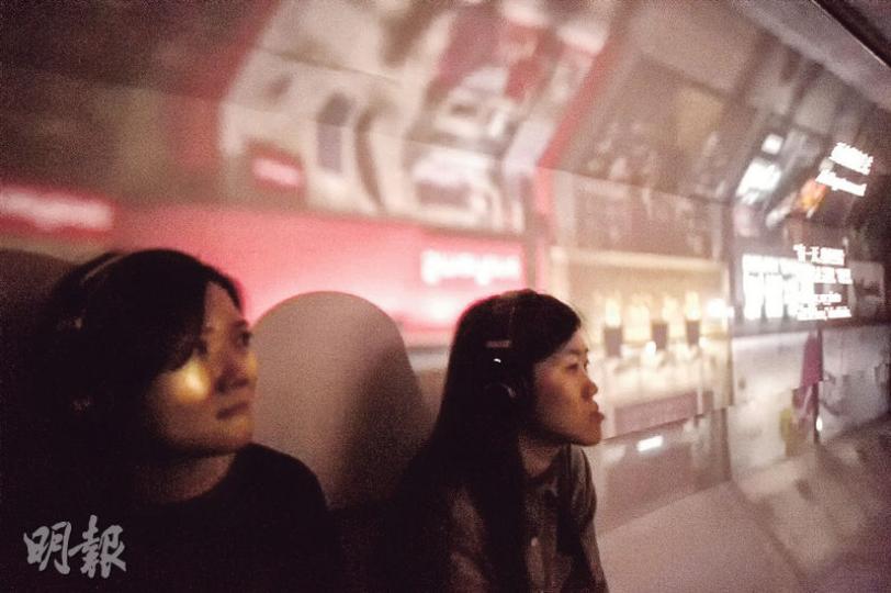 年輕藝術家伍韶勁的作品《25分鐘後》，利用流動相機暗室技術，把電車上層密封，留下兩個小孔讓光線透入，令車內人看到上下倒轉的車外景象，同場播放香港著名作家劉以鬯著作《對倒》的對白，部分對白投影在車箱內（圖右）。圖為早前《25分鐘後》在本港巴塞爾藝術展展出的情况。（馮凱鍵攝）伍韶勁把電車化作流動藝術品，早前在本港電車上演，下一站會在米蘭改裝電車，讓其流動藝術在米蘭道路上演。（馮凱鍵攝）