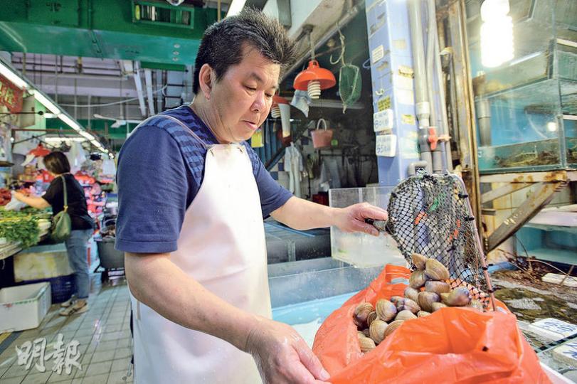九龍城街市新榮老闆阿添（圖中）前晚把即日未能售出、活生生的黃金蜆從水缸中撈出，捐贈予惜食組織。阿添沒有把海鮮再冷凍數天待售，至臨近變壞無法售出時才捐出，寧願早些捐出，讓領取者可多保存一兩天食用。（楊柏賢攝）阿添前晚把即日未能售出的各種魚蝦貝類，透過惜食組織轉贈予有需要人士。（楊柏賢攝）60多歲的李婆婆（圖）周五晚獲贈青口、蜆、豆腐和菜，她說自己獨自居住，這分量足夠自己吃多餐。她昔日是車衣女工，目前儉吃儉用，平日多數吃菜。（楊柏賢攝）
