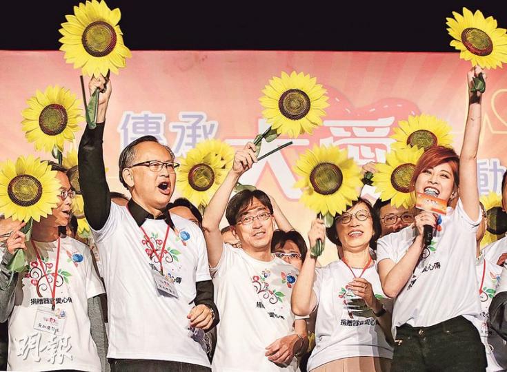 食衛局長高永文(前排左三)、副食衛局長陳肇始(前排左四)及香港移植學會前主席雷兆輝(前排左二)昨一起出席活動推廣器官捐贈,其間邊揮動太陽花,邊合唱《千個太陽》。(曾憲宗攝) 食衛局長高永文(前排左三)、副食衛局長陳肇始(前排左四)及香港移植學會前主席雷兆輝(前排左二)昨一起出席活動推廣器官捐贈,其間邊揮動太陽花,邊合唱《千個太陽》。(曾憲宗攝)