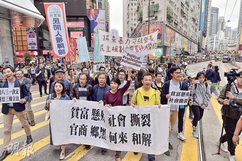 10多名民主派立法會議員(圖)昨帶領遊行隊伍由銅鑼灣東角道遊行至中環候任特首辦,沿途舉起標語和高叫口號,要求候任特首林鄭月娥回應重啟政改和落實全民退保等訴求。(馮凱鍵攝)社民連主席吳文遠(右下)昨攜同諷刺林鄭月娥的紙牌道具遊行,遊行隊伍到達終點冠君大廈時,欲將道具交予候任特首辦,但被自稱候任特首辦職員的人拒絕。(馮凱鍵攝) 10多名民主派立法會議員(圖)昨帶領遊行隊伍由銅鑼灣東角道遊行至中環候任特首辦,沿途舉起標語和高叫口號,要求候任特首林鄭月娥回應重啟政改和落實全民退保等訴求。(馮凱鍵攝)社民連主席吳文遠(右下)昨攜同諷刺林鄭月娥的紙牌道具遊行,遊行隊伍到達終點冠君大廈時,欲將道具交予候任特首辦,但被自稱候任特首辦職員的人拒絕。(馮凱鍵攝)
