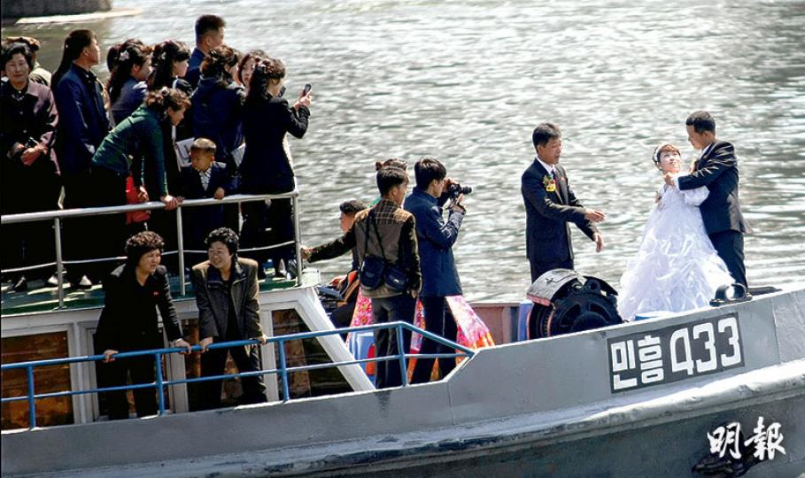 中朝邊境昨日氣氛平和,有朝鮮新娘穿着西式婚紗與新郎在快艇上擺姿勢拍照。(明報記者攝)朝鮮有新人在建軍節這天,乘遊船在鴨綠江上舉行「水上婚禮」,見記者拍照,他們也友善揮手示意。(明報記者攝)在鴨綠江大橋中國邊檢這一側,當值的公安邊檢人員看來似乎很輕鬆。(明報記者攝) 中朝邊境昨日氣氛平和,有朝鮮新娘穿着西式婚紗與新郎在快艇上擺姿勢拍照。(明報記者攝)朝鮮有新人在建軍節這天,乘遊船在鴨綠江上舉行「水上婚禮」,見記者拍照,他們也友善揮手示意。(明報記者攝)在鴨綠江大橋中國邊檢這一側,當值的公安邊檢人員看來似乎很輕鬆。(明報記者攝)