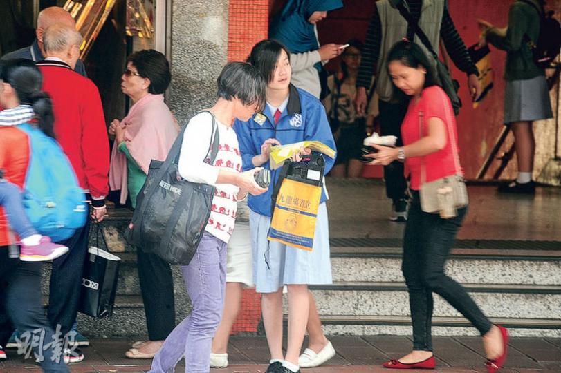 九龍樂善堂昨日在全港各區賣旗籌款,樂善堂王仲銘中學承認學生交還旗袋時會磅重,但強調屬鼓勵性質。圖為一名學生在北角賣旗。(衛永康攝) 九龍樂善堂昨日在全港各區賣旗籌款,樂善堂王仲銘中學承認學生交還旗袋時會磅重,但強調屬鼓勵性質。圖為一名學生在北角賣旗。(衛永康攝)