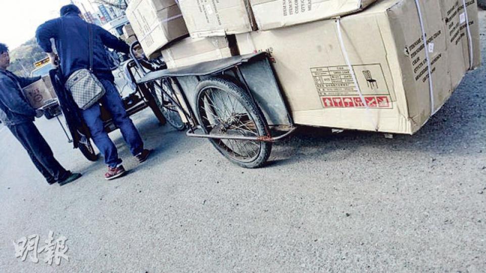 在丹東花園路跨境物流園區外,一名朝鮮貨櫃車司機在向小販購買多套車椅座墊。(明報記者攝) 在丹東花園路跨境物流園區外,一名朝鮮貨櫃車司機在向小販購買多套車椅座墊。(明報記者攝)