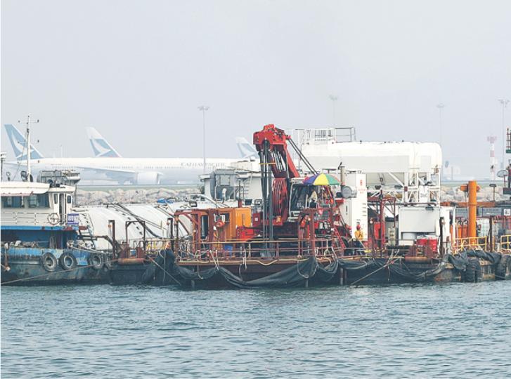 由於部分填海範圍鄰近機場北跑道,設嚴格高度限制,故需採用16艘躉船,配置較矮的低淨空高度鑽機(圖中間位置)填海。(曾憲宗攝) 由於部分填海範圍鄰近機場北跑道,設嚴格高度限制,故需採用16艘躉船,配置較矮的低淨空高度鑽機(圖中間位置)填海。(曾憲宗攝)