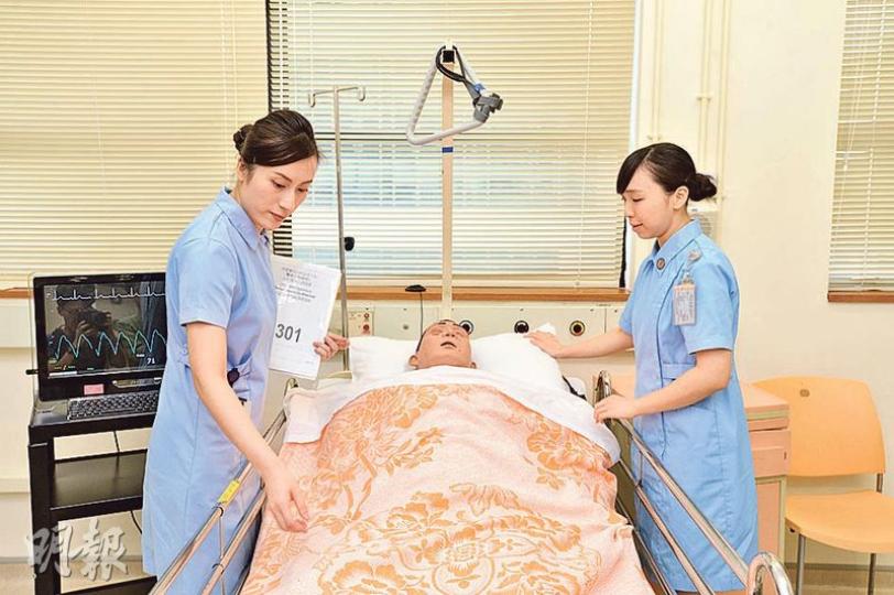 古佩蘭(左)及李凱晴(右)模擬平日上課的情形,包括學護需在實習室中,以假人作相關訓練,導師則在另一個房間觀察學護間的合作及處理手法。(楊柏賢攝) 古佩蘭(左)及李凱晴(右)模擬平日上課的情形,包括學護需在實習室中,以假人作相關訓練,導師則在另一個房間觀察學護間的合作及處理手法。(楊柏賢攝)