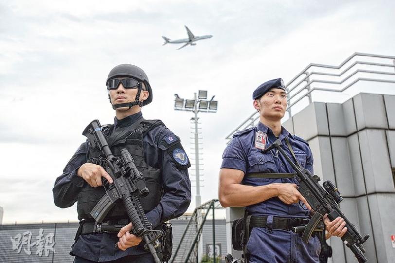 機場特警平常巡邏的制服及裝備共重約30多磅,並配備MP5衝鋒槍(右);當應付行動,須戴上特定頭盔、護眼罩及避彈衣等,其身穿的制服亦具防磨防火功能,全身裝備共重50多磅(左)。現時機場特警有132人,分成5隊,每隊23人中有6人會配備較先進的長距離步槍之一的M4突擊步槍(左所持的步槍),以便在高樓以中長距離伏擊可疑分子。(楊柏賢攝) 機場特警平常巡邏的制服及裝備共重約30多磅,並配備MP5衝鋒槍(右);當應付行動,須戴上特定頭盔、護眼罩及避彈衣等,其身穿的制服亦具防磨防火功能,全身裝備共重50多磅(左)。現時機場特警有132人,分成5隊,每隊23人中有6人會配備較先進的長距離步槍之一的M4突擊步槍(左所持的步槍),以便在高樓以中長距離伏擊可疑分子。(楊柏賢攝)