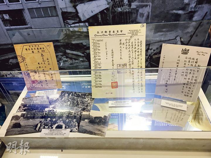 長洲氣象站中有唔少颱風相關歷史物品，包括颱風瑪麗吹襲長洲時嘅相片（左下方）、長洲各界就瑪麗風災籌款發出嘅收據（左上方）、長洲鄉委會致函天文台要求維修信號杆嘅信（中），以及天文台回信（右）。（呂少穎攝）長洲氣象站歷史館內有一部由天文台長岑智明借出嘅舊式收音機，喺導賞團時播放颱風警報信號嘅電台廣播。（呂少穎攝）