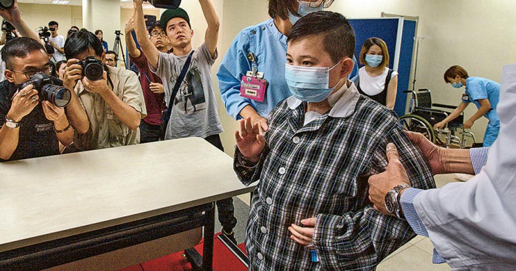 已換心的11歲男童鄧啟謙昨日出席記者會,瑪麗醫院心胸外科部門主管區永谷(右)輕扶他上台。謙仔向在場者輕輕揮手,表示對成功換心感到開心,並向捐贈者說多謝。(楊柏賢攝) 已換心的11歲男童鄧啟謙昨日出席記者會,瑪麗醫院心胸外科部門主管區永谷(右)輕扶他上台。謙仔向在場者輕輕揮手,表示對成功換心感到開心,並向捐贈者說多謝。(楊柏賢攝)