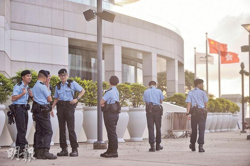昨傍晚起會展及金紫荊廣場外停泊多輛警車，大批警員在會展內外巡邏。（馮凱鍵攝）