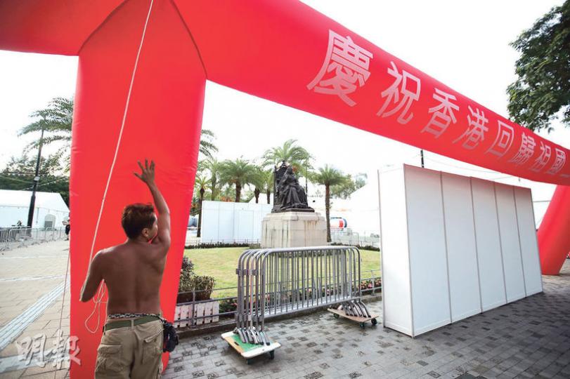 維園維多利亞女王銅像的正面及背面昨一度築起2.5米高圍板,並豎起寫有慶祝回歸字句的大型吹氣裝置,如從高士威道望入維園,女王像被完全遮檔。本報記者拍攝後不久,有工作人員將吹氣裝置拆除。(曾憲宗攝) 維園維多利亞女王銅像的正面及背面昨一度築起2.5米高圍板,並豎起寫有慶祝回歸字句的大型吹氣裝置,如從高士威道望入維園,女王像被完全遮檔。本報記者拍攝後不久,有工作人員將吹氣裝置拆除。(曾憲宗攝)