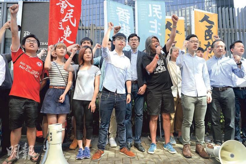 早前佔據金紫荊雕像被捕的26名社運人士,被警方長時間扣留後昨相繼獲釋,香港眾志秘書長黃之鋒(前左四)強調,各人會繼續參與今日舉行的民陣七一遊行。(鍾林枝攝) 早前佔據金紫荊雕像被捕的26名社運人士,被警方長時間扣留後昨相繼獲釋,香港眾志秘書長黃之鋒(前左四)強調,各人會繼續參與今日舉行的民陣七一遊行。(鍾林枝攝)