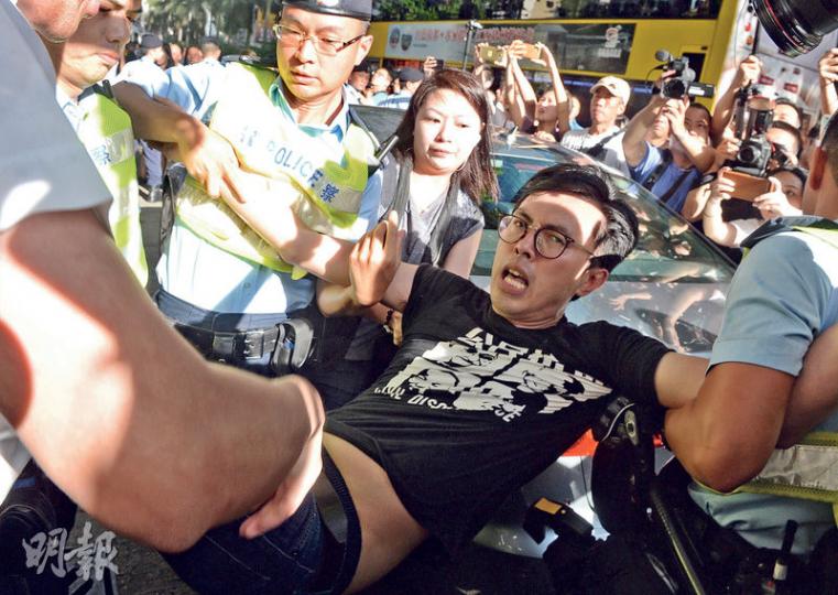 警方以公眾安全為由,昨晨在灣仔港鐵站外帶走擬往示威的社民連及香港眾志成員逾20人,令各人無法前往會展示威。圖為社民連主席吳文遠被警員抬走(圖),他表示,在場警員沒解釋拘捕理由,他投訴被抬上警車後,有警員扯其頭髮並把其頭部推向車窗。(劉焌陶攝)社民連、香港眾志的成員,與反對他們的示威者激烈推撞,警方一度嘗試分開兩批人,最終拘捕4名涉襲擊社民連成員的男子,另帶走社民連及眾志約20名成員。(劉焌陶攝)一名身上帶着回鄉證、涉搗毁社民連物品的林姓男子被捕。(劉焌陶攝)社民連主席吳文遠(左)及成員陳皓桓(右 警方以公眾安全為由,昨晨在灣仔港鐵站外帶走擬往示威的社民連及香港眾志成員逾20人,令各人無法前往會展示威。圖為社民連主席吳文遠被警員抬走(圖),他表示,在場警員沒解釋拘捕理由,他投訴被抬上警車後,有警員扯其頭髮並把其頭部推向車窗。(劉焌陶攝)社民連、香港眾志的成員,與反對他們的示威者激烈推撞,警方一度嘗試分開兩批人,最終拘捕4名涉襲擊社民連成員的男子,另帶走社民連及眾志約20名成員。(劉焌陶攝)一名身上帶着回鄉證、涉搗毁社民連物品的林姓男子被捕。(劉焌陶攝)社民連主席吳文遠(左)及成員陳皓桓(右