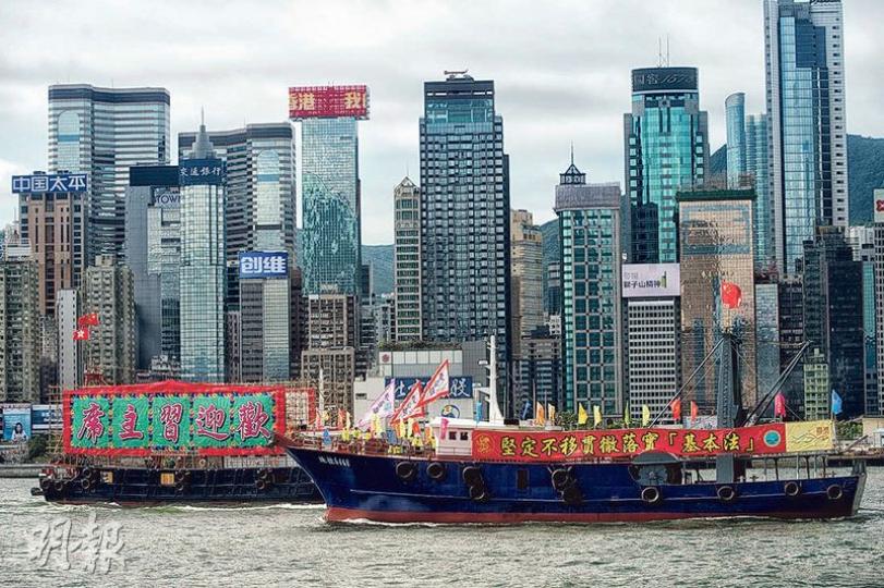 新界各界慶委會及香港漁民團體聯會昨發動100艘漁船在維港巡遊,途經正舉行升旗儀式及慶典的會展,船上掛有「堅定不移貫徹落實『基本法』」、「歡迎習主席」等字句的橫額。(馮凱鍵攝) 新界各界慶委會及香港漁民團體聯會昨發動100艘漁船在維港巡遊,途經正舉行升旗儀式及慶典的會展,船上掛有「堅定不移貫徹落實『基本法』」、「歡迎習主席」等字句的橫額。(馮凱鍵攝)